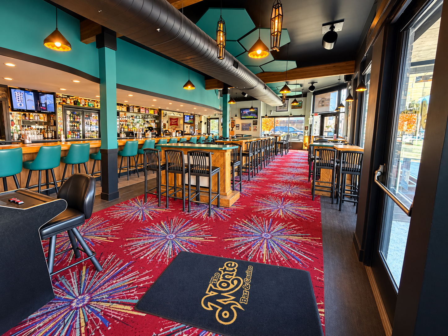 The Monte interior with teal bar chairs, high-top tables and red starburst carpet