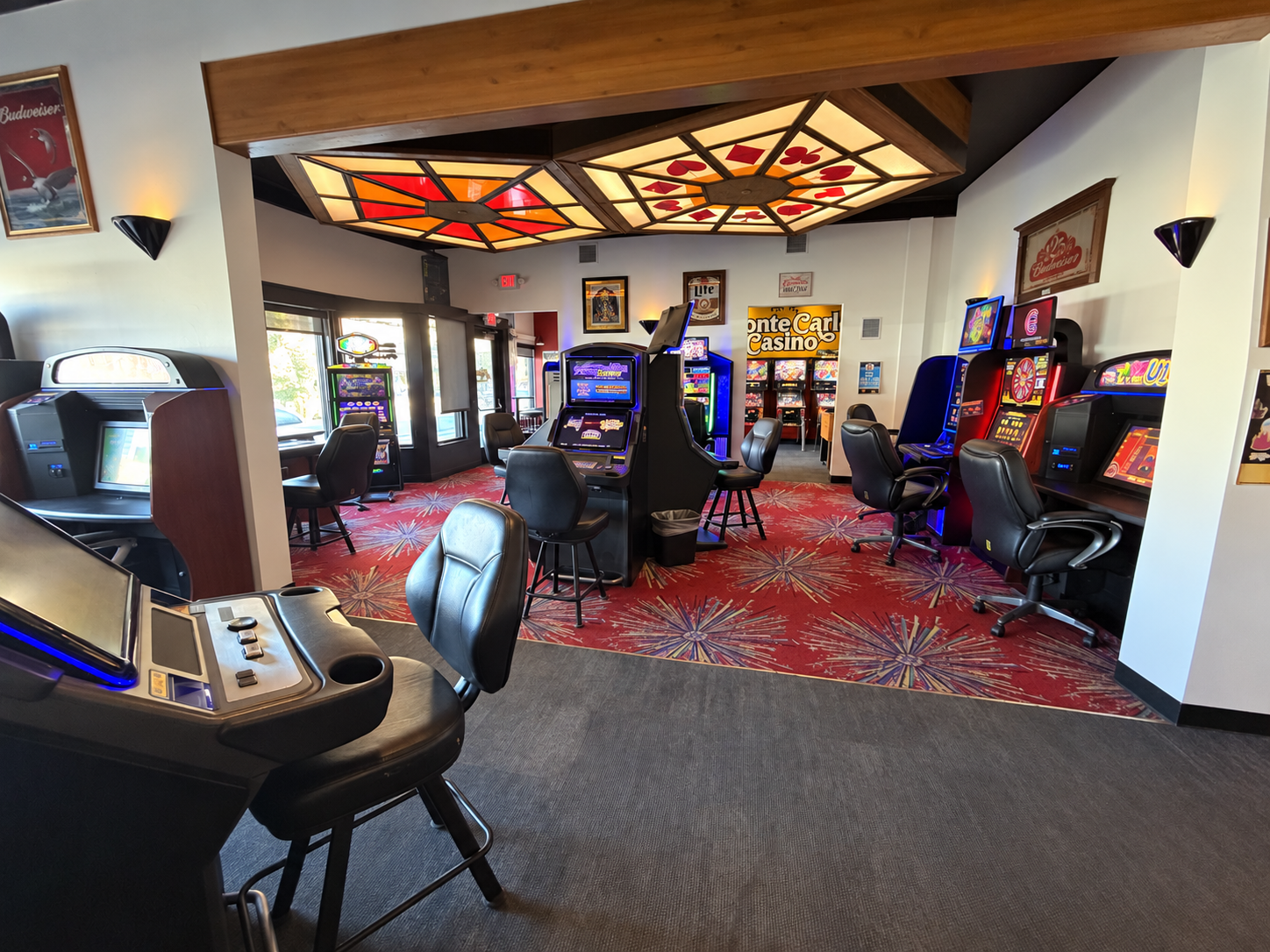 The Monte casino gaming area with machines and chairs beneath illuminated stained-glass ceiling panels